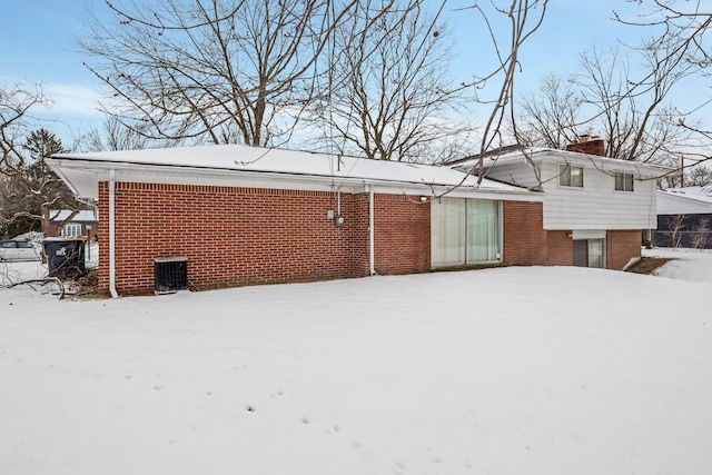 snow covered property with central AC unit