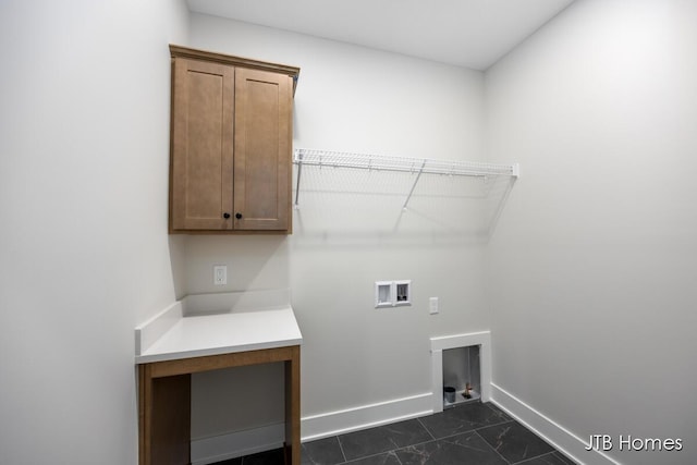 clothes washing area with washer hookup and cabinets