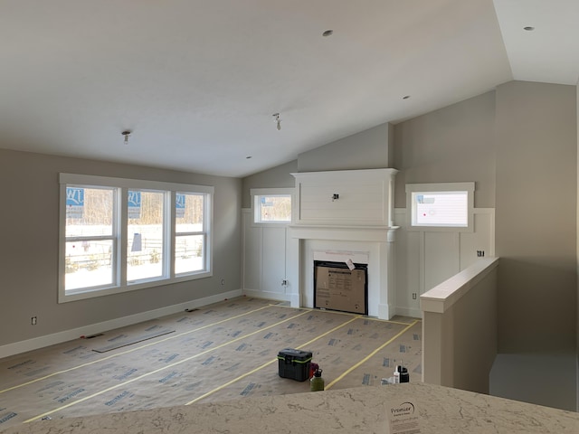 unfurnished living room featuring vaulted ceiling