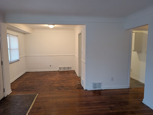 spare room featuring dark wood-type flooring