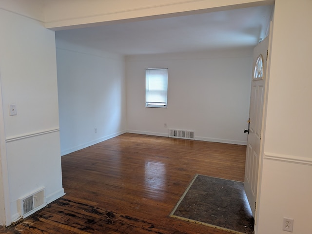 spare room featuring dark wood-type flooring