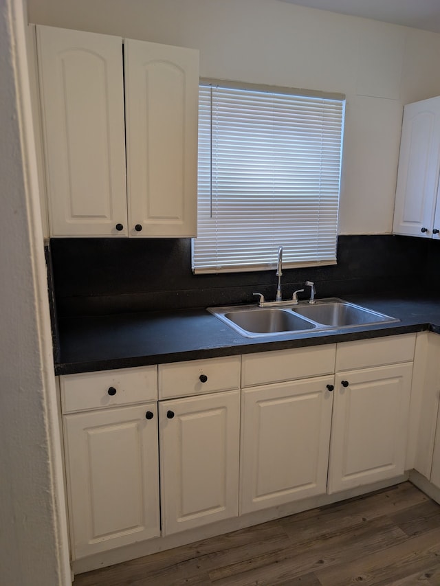 kitchen with tasteful backsplash, white cabinets, dark hardwood / wood-style flooring, and sink