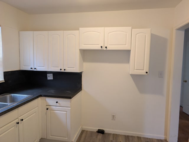 kitchen with white cabinetry, dark hardwood / wood-style flooring, and sink