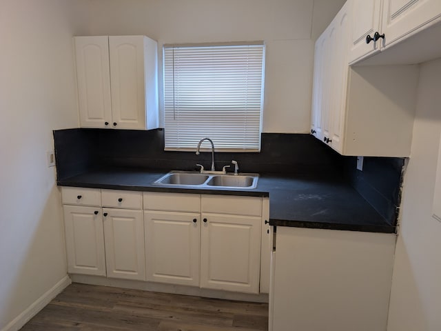 kitchen with dark wood-type flooring, sink, and white cabinetry