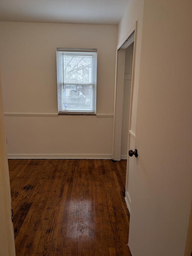 unfurnished bedroom with a closet and dark hardwood / wood-style floors