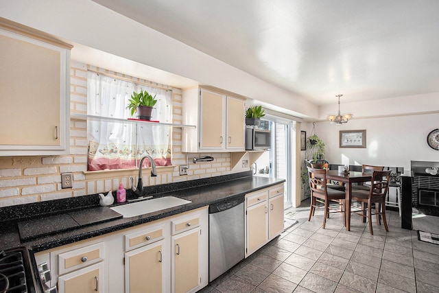 kitchen featuring decorative backsplash, decorative light fixtures, appliances with stainless steel finishes, a sink, and an inviting chandelier
