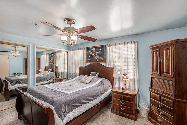 bedroom with light colored carpet, two closets, and multiple windows