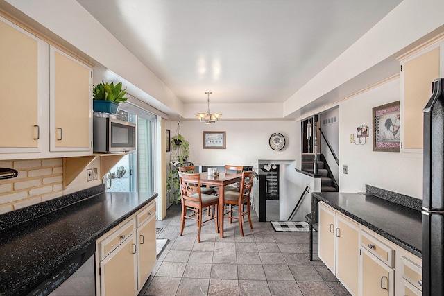 kitchen featuring dark countertops, cream cabinets, tasteful backsplash, a notable chandelier, and stainless steel appliances