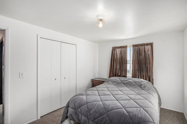 carpeted bedroom featuring baseboards and a closet