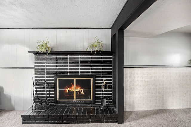 interior details featuring a textured ceiling, a brick fireplace, wood walls, and carpet floors