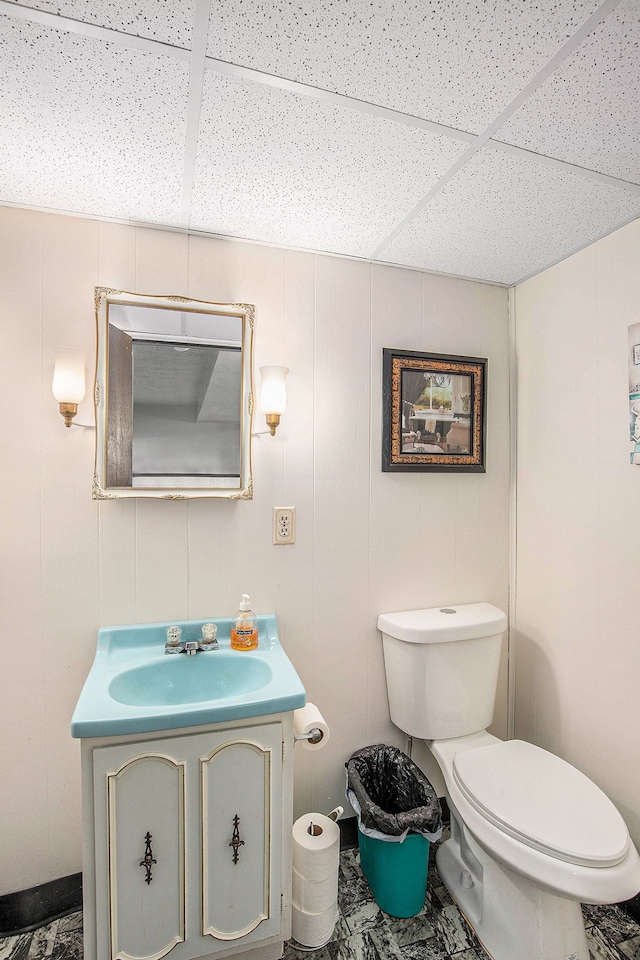 bathroom featuring a paneled ceiling, vanity, and toilet