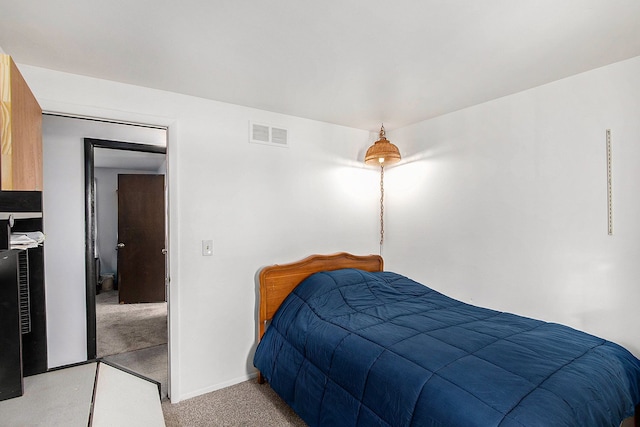 bedroom with baseboards, visible vents, and light carpet