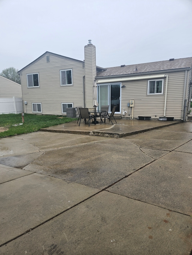 rear view of property featuring a patio and a chimney