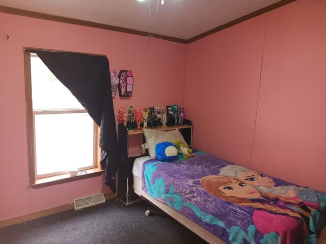 bedroom with a textured ceiling, crown molding, multiple windows, and carpet flooring