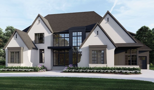 view of front of house featuring a front lawn, roof with shingles, and stucco siding