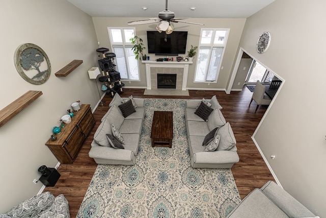 living room featuring a fireplace, ceiling fan, and dark hardwood / wood-style floors