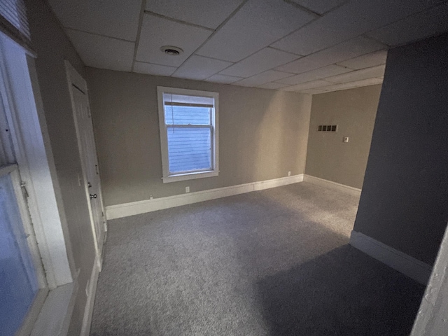 empty room featuring a drop ceiling and carpet floors