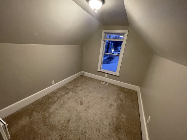 bonus room with carpet floors and vaulted ceiling