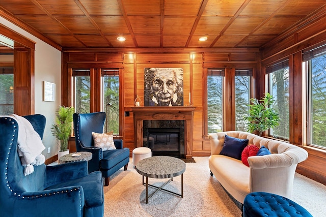 living area featuring a fireplace, carpet flooring, wood ceiling, and wood walls