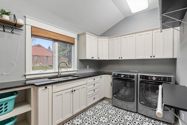clothes washing area with washer and dryer, light tile patterned floors, cabinets, and sink