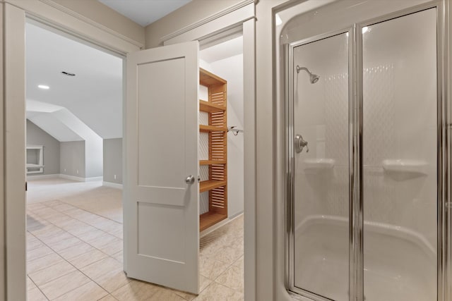 bathroom with tile patterned flooring, lofted ceiling, and a shower with shower door