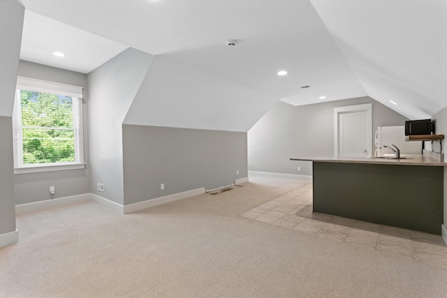 bonus room featuring light carpet, sink, and lofted ceiling
