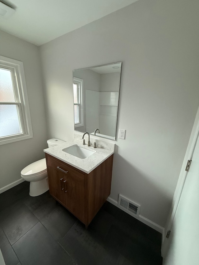 bathroom with toilet, tile patterned flooring, and vanity