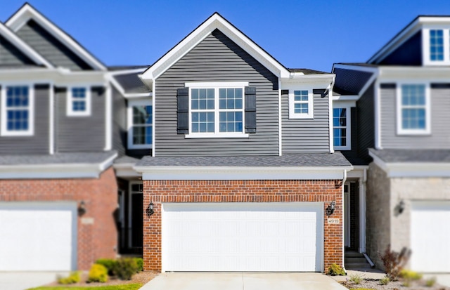 view of front of house featuring a garage, brick siding, and driveway