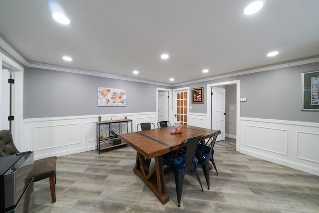 dining area featuring ornamental molding and light wood-type flooring