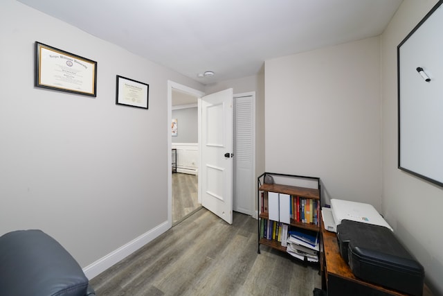 interior space featuring a baseboard heating unit and hardwood / wood-style flooring