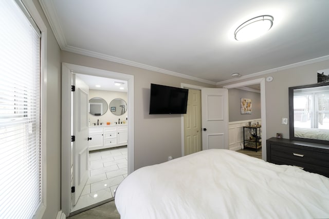 tiled bedroom with ensuite bathroom, crown molding, and sink