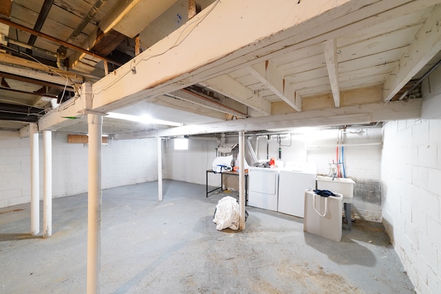 basement featuring washer and clothes dryer and sink