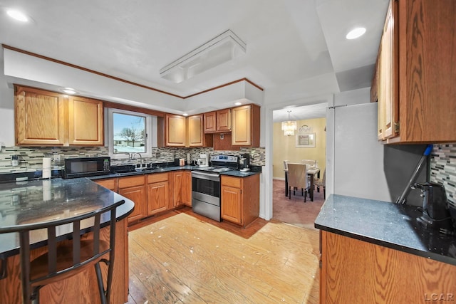 kitchen featuring sink, light hardwood / wood-style flooring, a notable chandelier, electric stove, and decorative backsplash