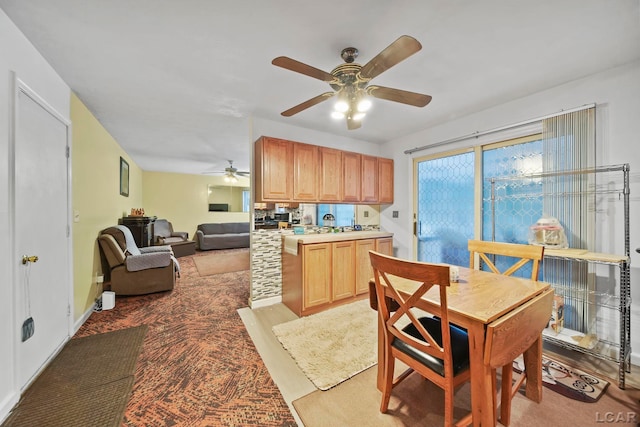 kitchen featuring ceiling fan, light brown cabinets, kitchen peninsula, and light carpet