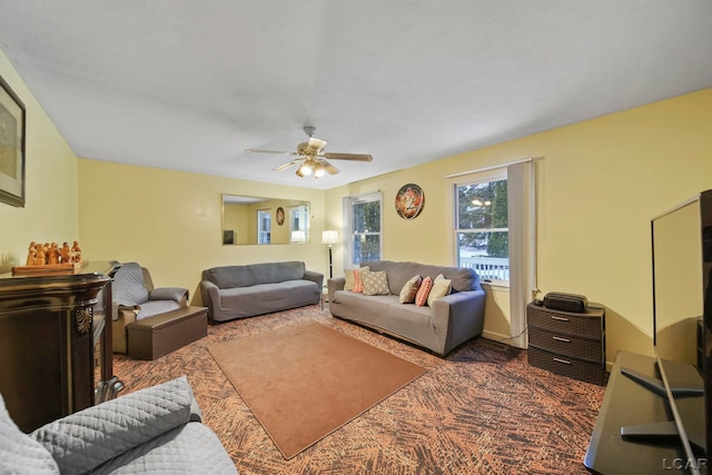 living room featuring dark carpet and ceiling fan