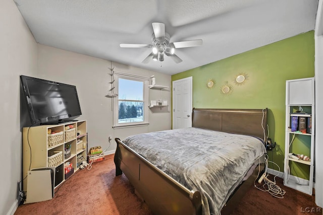 bedroom with ceiling fan, dark carpet, and a textured ceiling