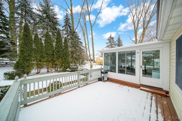 snow covered deck featuring a sunroom