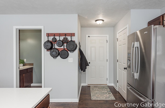 kitchen featuring stainless steel fridge, dark hardwood / wood-style flooring, and a textured ceiling