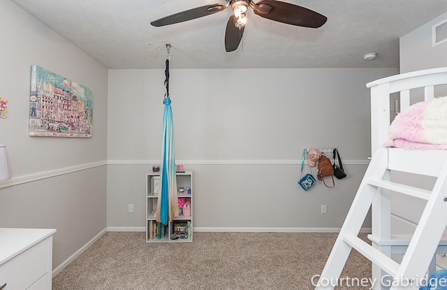 unfurnished bedroom with ceiling fan, carpet, and a textured ceiling