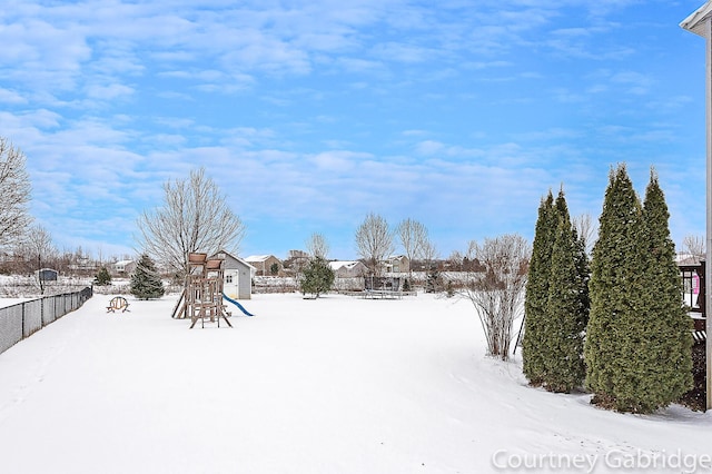 yard covered in snow with a playground