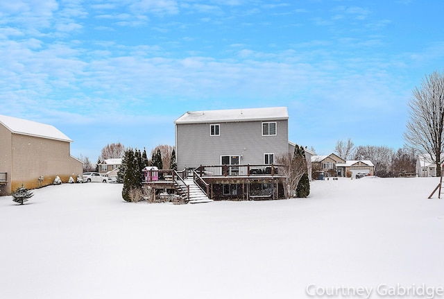 snow covered house with a wooden deck