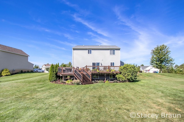 rear view of house featuring a yard and a deck