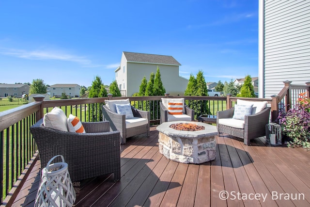 wooden terrace with an outdoor living space with a fire pit