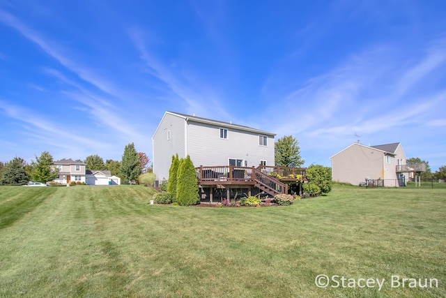 rear view of property with a deck and a lawn