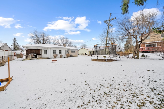 snowy yard featuring a trampoline