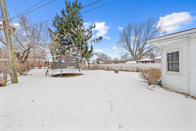 yard covered in snow featuring a trampoline