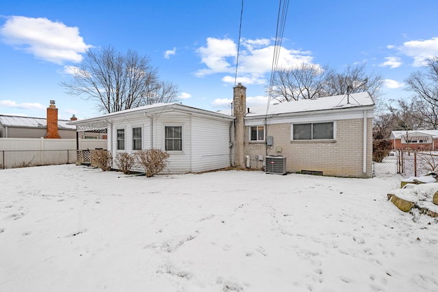 snow covered house featuring central AC