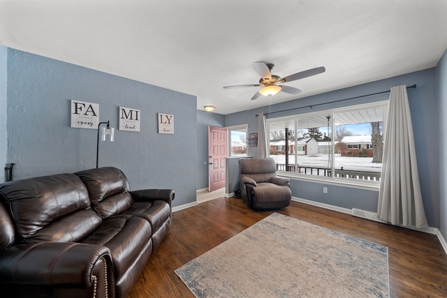 living room with ceiling fan and dark hardwood / wood-style flooring