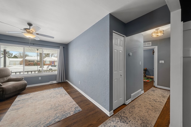 sitting room featuring dark wood-type flooring and ceiling fan