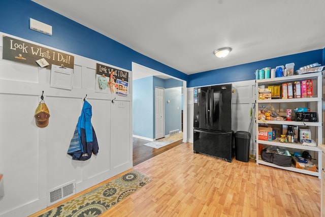 interior space with black refrigerator and hardwood / wood-style floors